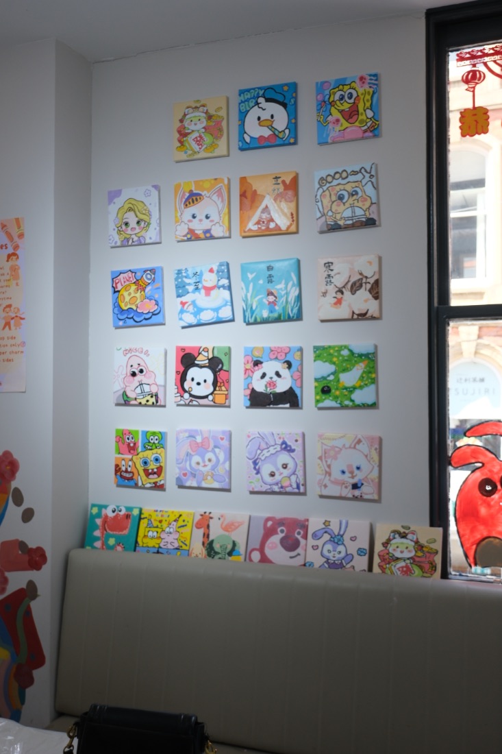 Mini canvas paintings on the pegboard wall